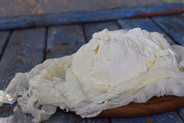 Cottage cheese from curdled milk or yoghurt on a wooden background