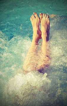 Woman with beautiful long legs in the pool with  vintage effect