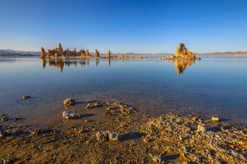 The popular calcareous tufa formation reflects on the smooth waters of Mono Lake, one of the oldest lakes in North America. The Mono Lake Tufa State Natural Reserve, California, United States.