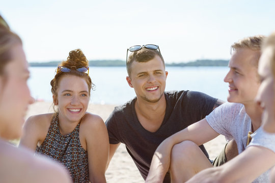 Group of young students chatting at the beach