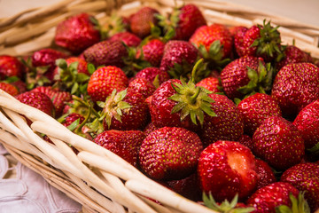 Strawberries lie in a wooden wicker basket