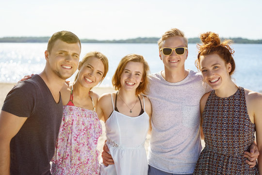 Happy group of young university students on a beach