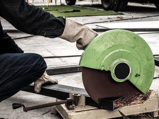 The mechanic is cutting steel with sparkle.