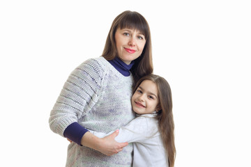 mom hugs her little daughter and smiles at the camera