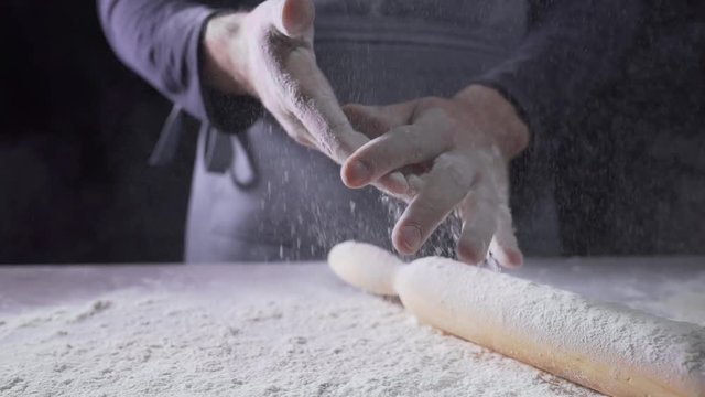The cook's hands in flour, baker at work, bread and bakery, flour at the kitchen
