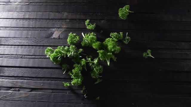 Chopped parsley falls fto the wooden board, fresh greens, vegetables and vitamins, healthy food