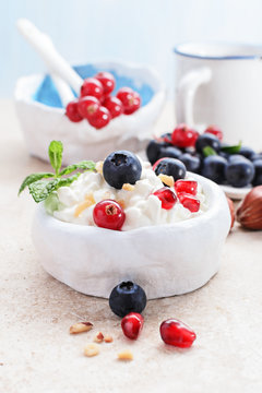 Cottage cheese with berries on light background.