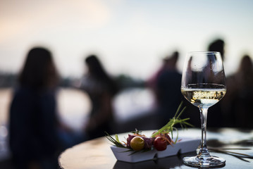 glass of white wine with gourmet food tapa snacks outside