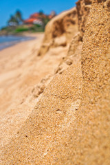 Fototapeta na wymiar Blurred yellow sand on the backdrop of a beautiful villa, Indian Ocean, sea. Untouched tropical beach in Sri Lanka. Stock photo for design