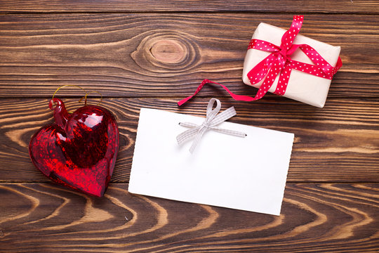 Festive gift box with present  and empty tag on aged  wooden background.