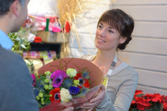 florist giving brunch of flowers to customer
