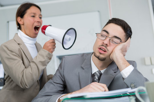 business woman nearworkmate asking him to wake up