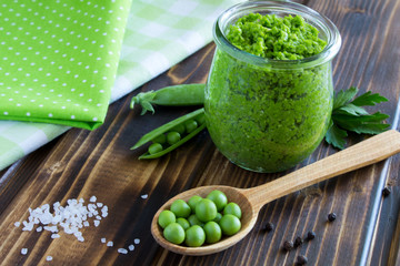 Pea mash in the glass jar on the wooden background