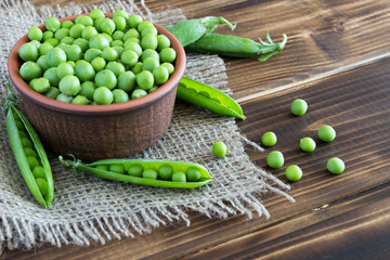 Peas in ceramic plate on the wooden background