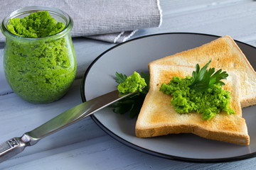 Bread toast with pea mash on the grey plate