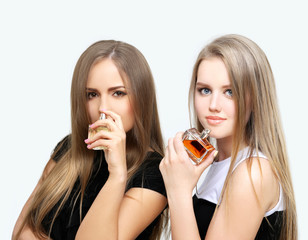 Perfume. Two girls smelling aroma .