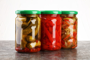 Jar with variety of pickled vegetables. Carrots, field garlic, cucumber in glas. Preserved food