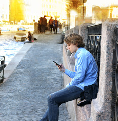 Teenage boy typing text message.Using smart phone