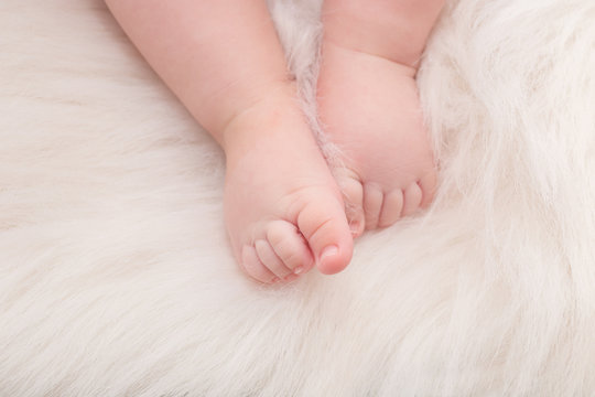 Baby feet in soft white blanket