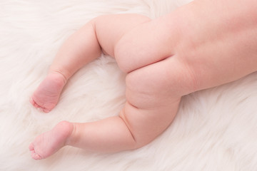 Close up baby bottom lying on white cloth background - 161898337