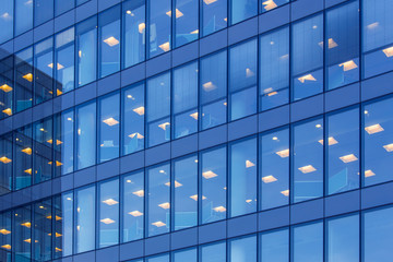 office building windows with inner artificial lamplight in blue color tone