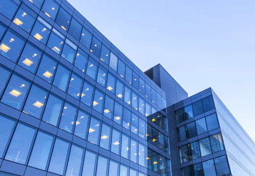 office building windows with inner artificial lamplight in blue color tone