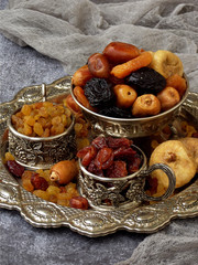 A composition from different varieties of dried fruits on a wooden background - dates, figs, apricots, prunes, raisins, cranberries. Healty food.