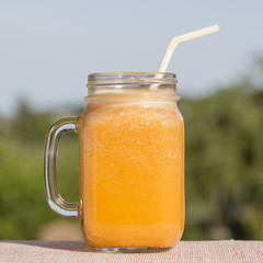Smoothies from carrot, lemon, honey and banana in glass