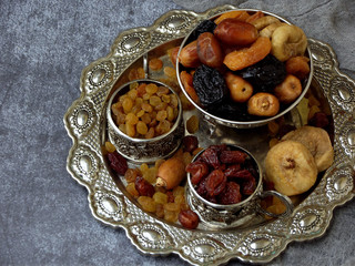 A composition from different varieties of dried fruits on a wooden background - dates, figs, apricots, prunes, raisins, cranberries. Healty food.