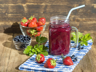 Health smoothie from strawberry, blueberry and banana in Mason jar mug