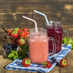 Two health smoothie from strawberry, blueberry, raspberry and banana in mason jar mug