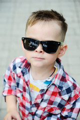 Baby boy in plaid shirt with sunglasses. Children's fashion