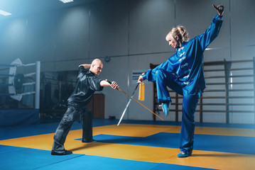 Fototapeta na wymiar Wushu fighters, man and woman with swords