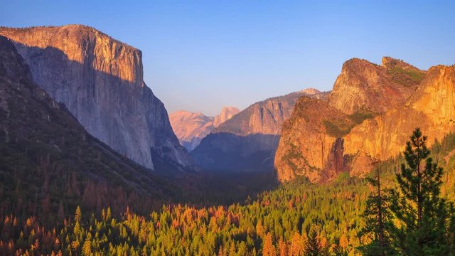 Yosemite National Park at iconic Tunnel View overlook. Front view of popular El Capitan and Half Dome at sunset in California, United States. Sunset closeup time lapse with changing light to night.