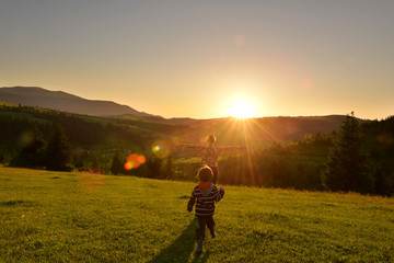 Fototapeta na wymiar Kid running at sunset in the mountains