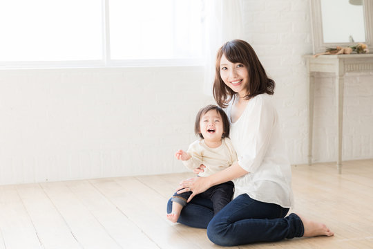 asian mother and child relaxing in living room