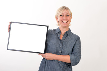 beautiful european mid aged woman in business dress holding a blank white board - studio shot in front of a white background