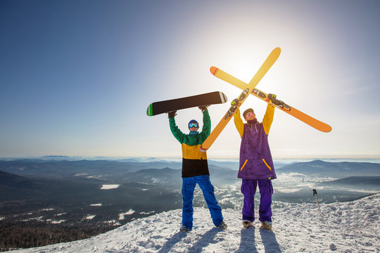 Skier and snowboarder on mountain top. Sunny winter day, active sport holiday