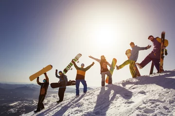 Crédence de cuisine en verre imprimé Sports dhiver Groupe de personnes snowboarders et skieurs au coucher du soleil sur la montagne. Sports d& 39 hiver en plein air