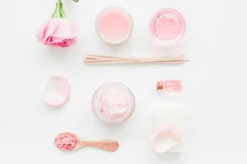homemade spa with rose cosmetic set, cream, salt and oil on white background top view
