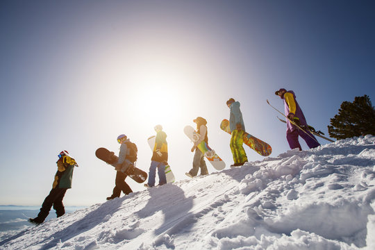 Group of people snowboarders and skiers on mountain sunset. Winter Sport outdoor