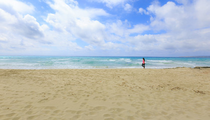 Fototapeta na wymiar Girl walking on the beach