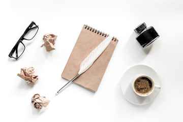 Writer concept. Feather pen, vintage notebook and crumpled paper on white background top view