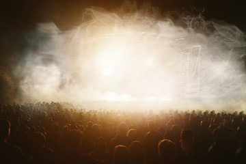 Crowd at concert in front of bright colorful stage lights - obrazy, fototapety, plakaty