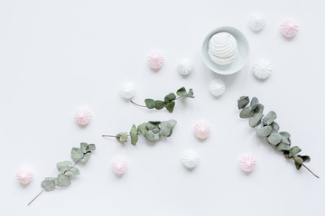 light breakfast with marsh-mallow and plant on white table background top view