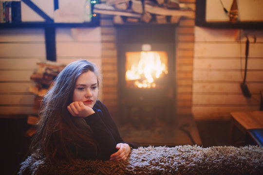 Portrait of young female sitting near fireplace
