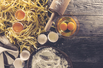 Process of cooking pasta with raw fresh ingredients for classic italian food - raw eggs, flour on...