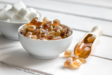 white and brown sugar for cooking sweets on kitchen white wooden table close up