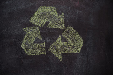 Green recycled symbol drawn with chalk on blackboard