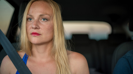 Plakat Attractive blonde girl sitting in the car